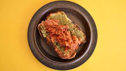 A tuna and bean mix with BBQ sauce on toasted cob bread with basil pesto.