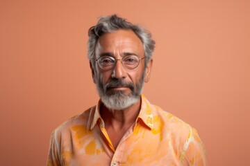 Obraz premium A man with a beard and glasses is wearing a yellow shirt