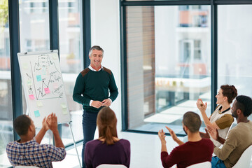 Man, whiteboard and presentation in office with applause, stats and success with graphs at startup. Mature speaker, business people and cheers with charts, goals and sales review at creative agency