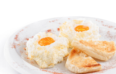 Delicious eggs in clouds with toasts on white plate being sprinkled with red pepper