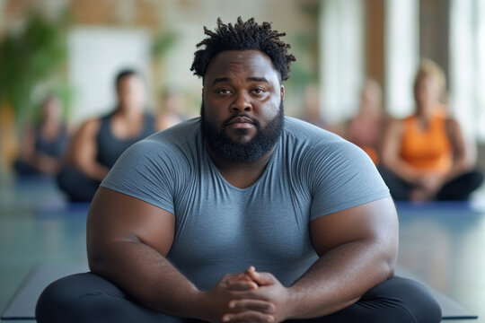Focused man practicing yoga in group meditation session