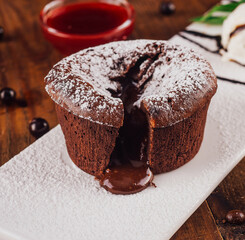 Delicious chocolate lava cake oozing on white plate with ice cream