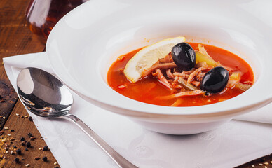 Delicious russian soup solyanka being served on a wooden table