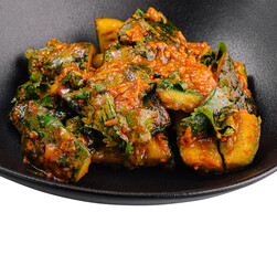 Spicy cucumber salad sprinkled with cilantro in black bowl