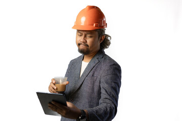 Indonesian male construction worker standing confidently and optimistically carrying a tablet and a cup of coffee, industrial and construction concept, isolated white background.
