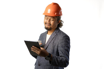 Indonesian male construction worker standing confidently and optimistically carrying a tablet and a cup of coffee, industrial and construction concept, isolated white background.
