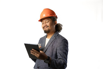 Indonesian male construction worker standing confidently and optimistically carrying a tablet and a cup of coffee, industrial and construction concept, isolated white background.
