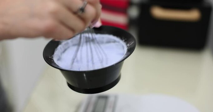 Mix hair bleach with a whisk in a bowl