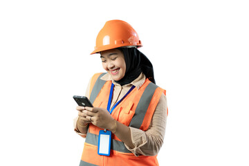 A woman wearing an orange safety vest and hard hat smiles while talking on a smartphone. She gestures confidently with her other hand, standing against a white background, with a blue lanyard and ID b