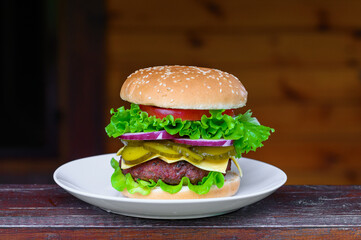 Ogromny cheeseburger z domową bułeczką, domowy fast food, burger wołowy z sałatą  warzywami 