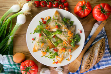 Baked brick pastry triangles filled with eggplant. Top view table with  decoration.