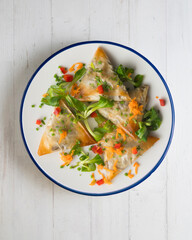 Baked brick pastry triangles filled with eggplant. Top view table with  decoration.