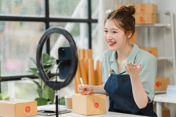 Small Business, Big Dreams: A young Asian entrepreneur beams with excitement as she interacts with...