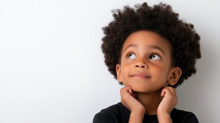 A young child with curly hair is looking up at the camera with a smile on his face. Concept of innocence and curiosity, as the child seems to be pondering something or simply enjoying the moment