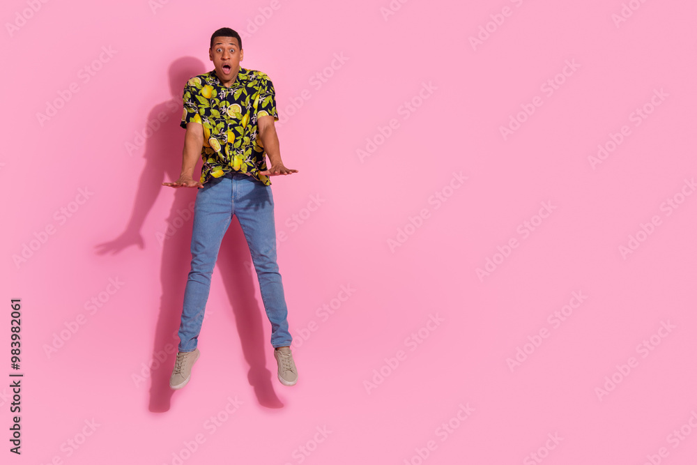 Poster Full length photo of young guy amazed jumping pushing invisible things dressed tropical print garment isolated on pink color background