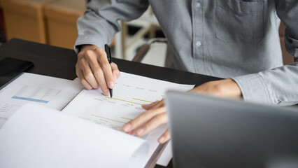 Asian business man holding paper document calculating tax insurance managing budget