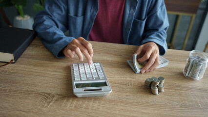 Man calculates finances by calculator Count banknotes and coinsใ