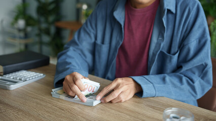 Man planning finances Count banknotes and coinsใ