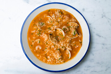 Rice soup with shrimp and clams. Top view table with  decoration.