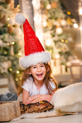 Child in a red cap at Christmas. Little cheerful girl in a red cap at Christmas.