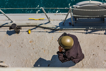 marines in white uniforms and officers on a battleship. combat scientists at sea. war in ukraine and black sea. old russian ships. military sailors talking on radios, watching other ships. military po