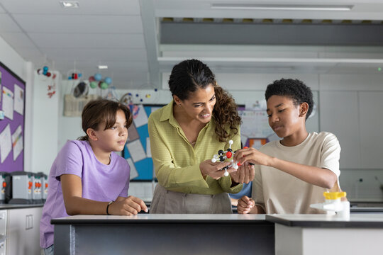 Female science teacher showing a molecular model to pupils