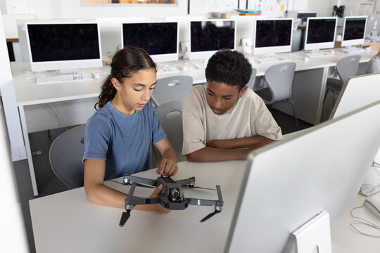 School students looking at a drone in computer science class