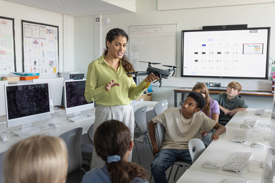 Computer science teacher showing class of students a drone