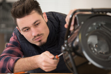 man tightening screw on professional lighting projector