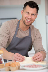 handsome man cooking at home preparing salad in kitchen