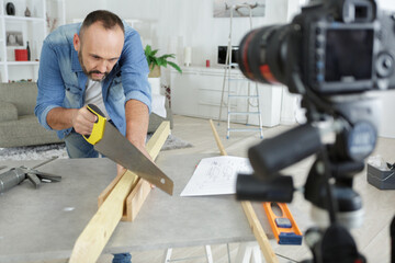 man cuts a wood plank at home