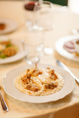 Close up on italian traditional northern food on a restaurant table. Risotto with frogs legs.