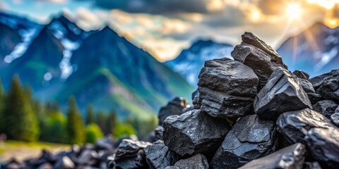 Obraz premium Jagged Charcoal Rocks in Foreground Under Warm Sunset Light Amidst Hazy Blue Mountain Range and Vibrant Sky, Creating Depth and Tranquility in Nature's Embrace
