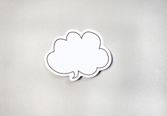 Single white speech bubble adhesive notes, blank on light grey surface