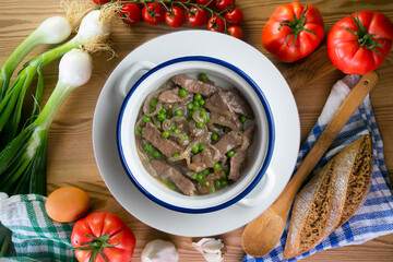 Strips of beef cooked with onion and peas. Top view table with  decoration.
