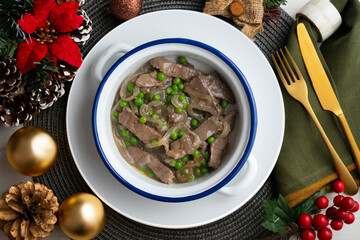 Strips of beef cooked with onion and peas. Top view table with Christmas decoration.