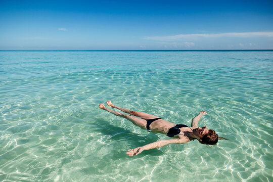 Woman floating in clear waters of Varadero Beach, Cuba