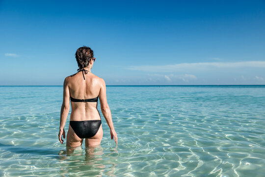 Back view of unrecognizable woman enjoying Varadero Beach
