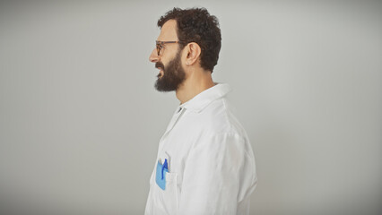 Side profile of a bearded middle-aged man in glasses wearing a lab coat with pens in pocket against a white background.