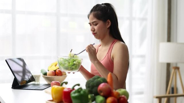 A young Asian woman who eats vegetable salad every day is bored with vegetables. Unhappy women is on dieting time looking vegetable on the fork. girl do not want to eat vegetables and dislike taste.
