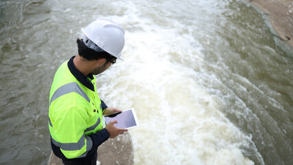 Male engineer working in hydroelectric dam. Ecology orientated. Renewable energy systems.