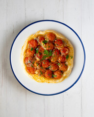 Savory tarte tatin with cherry tomatoes. Top view table with  decoration.