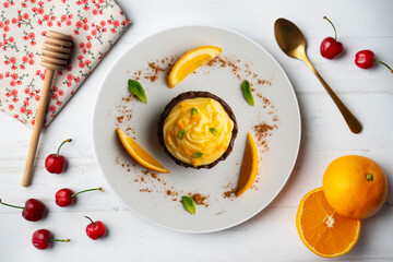 Chocolate tartlets with orange cream. Top view table with  decoration.