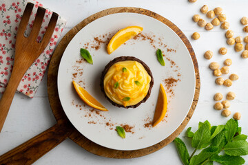 Chocolate tartlets with orange cream. Top view table with  decoration.