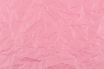 Close-up fragment of a pink magenta crumpled paper texture as a backdrop.