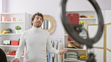 Handsome hispanic man wearing a turtleneck poses in a well-organized wardrobe room, surrounded by clothing and accessories.