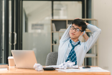 Obraz premium A relaxed office worker takes a moment to unwind at his desk, showcasing a blend of focus and leisure in a modern workspace.