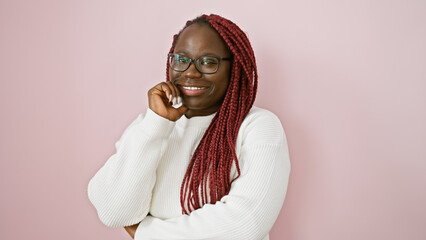 African american woman with braids smiling over an isolated pink background, personifying beauty...