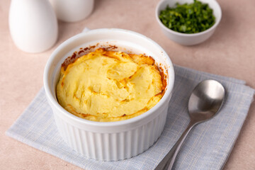 Shepherd's pie in a portioned white baking dish. Homemade traditional casserole (gratin) with minced meat and mashed potatoes. Selective focus, close-up.