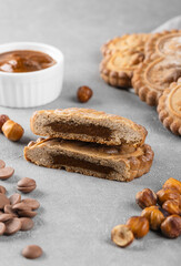 Sliced gingerbread cookies with chocolate and nut filling on a gray background. Home baking concept.